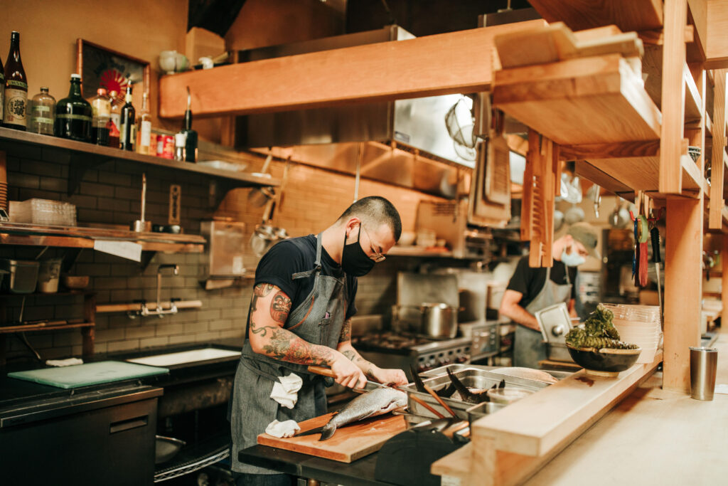 A person preparing fish at San Francisco restaurant Izakaya Rintaro